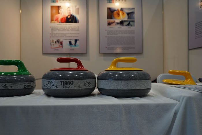 Granite curling stones with green, red and yellow handles
