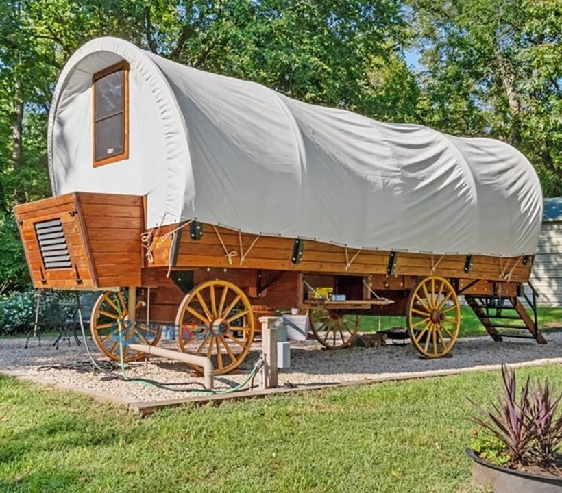 21 ft glamping covered wagon with canvas cover on a campground