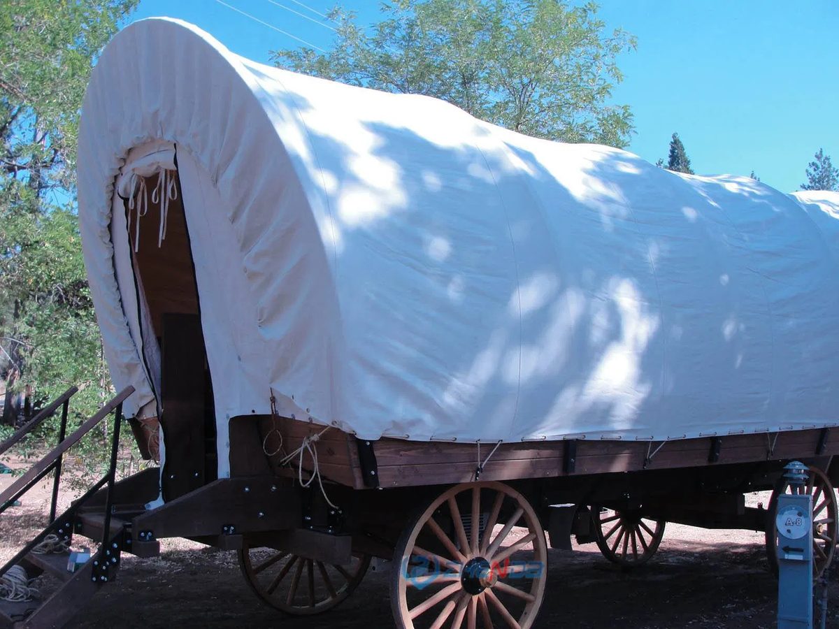 Glamping covered wagon on a property, side view